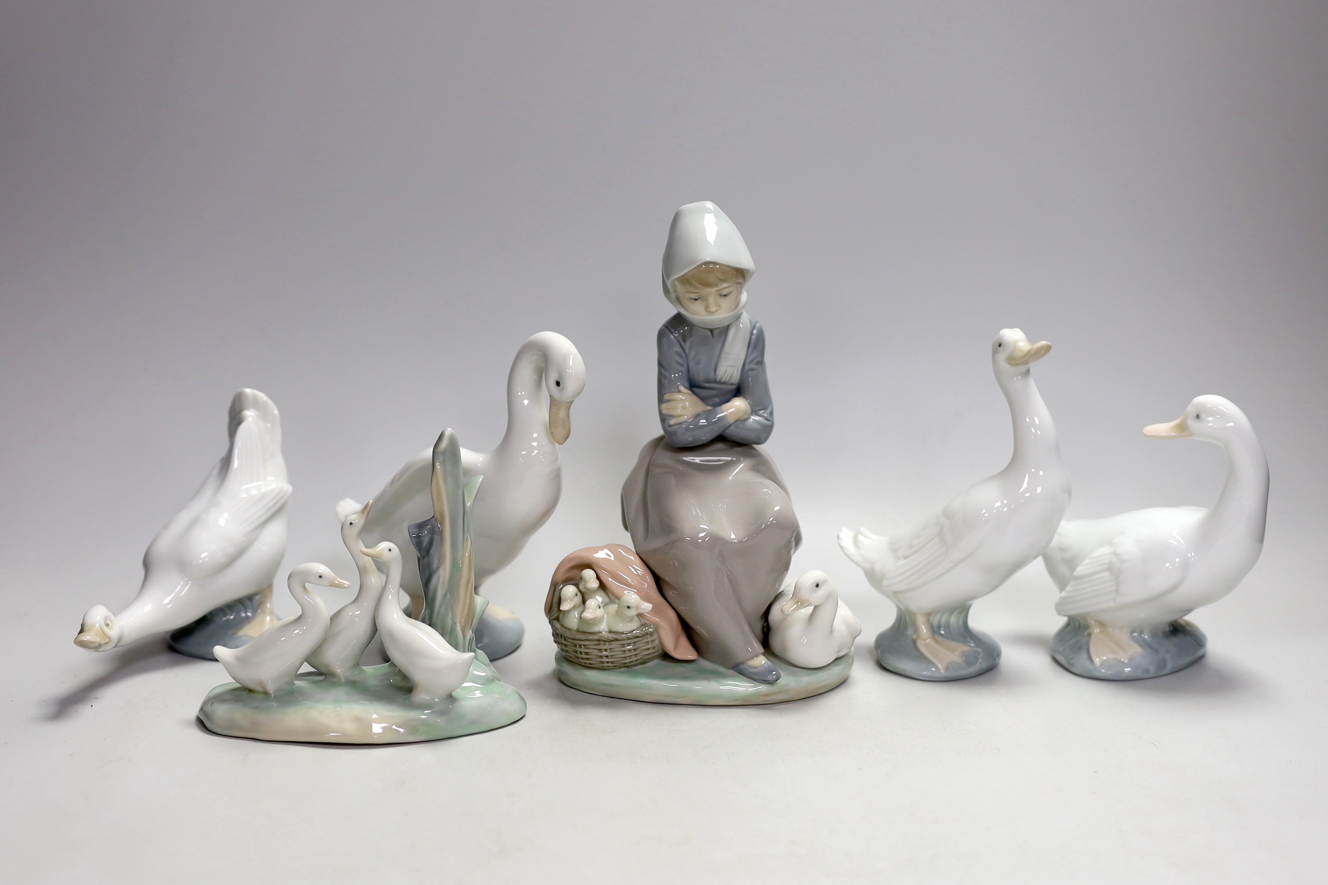 A Lladro seated girl with ducks and five Nao ducks